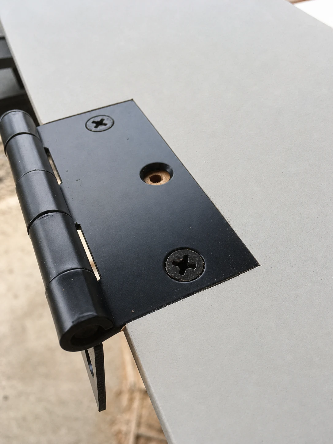 Close detail of a precisely mortised black door hinge